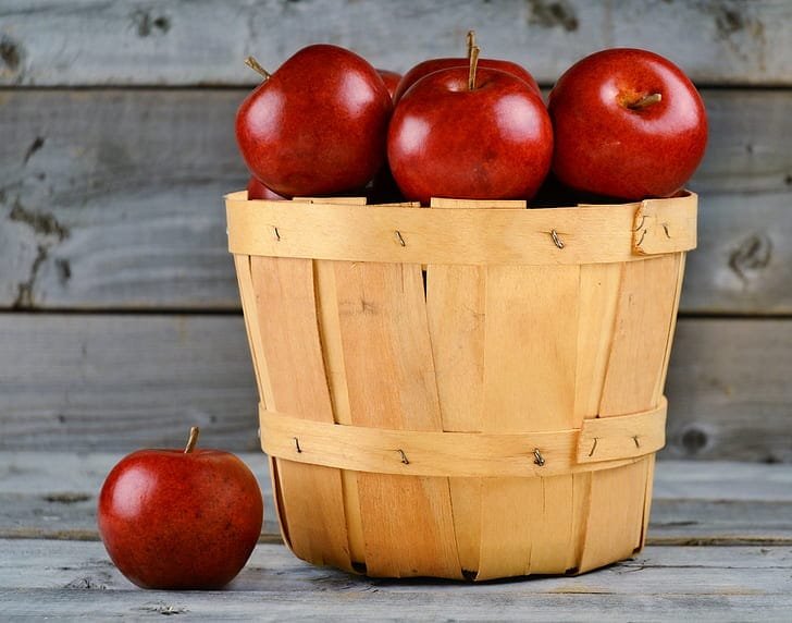 Fresh red apples in a wooden basket